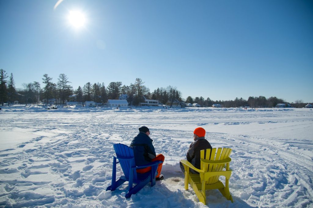 Severn Ice Fishing two people in muskoka chairs on frozen lake on a sunny day