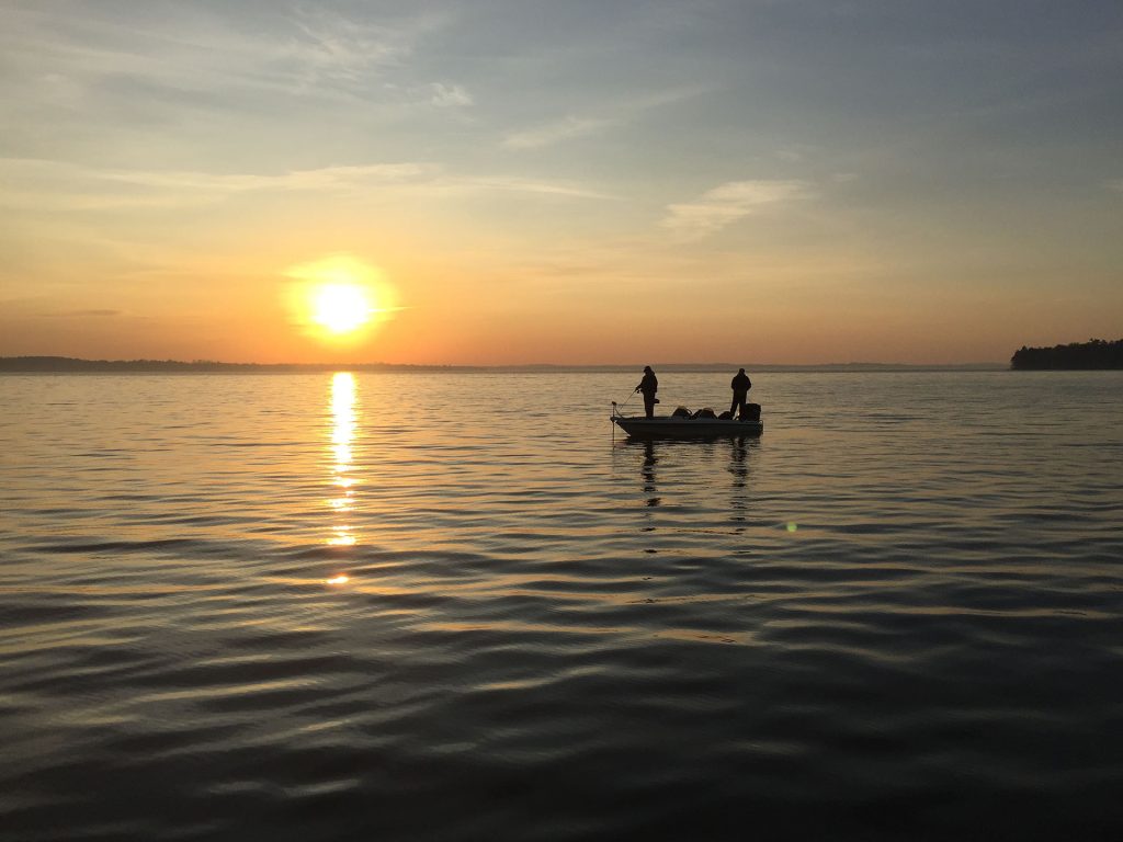 Ice fishers silhouetted at sunset on Lake Couchiching