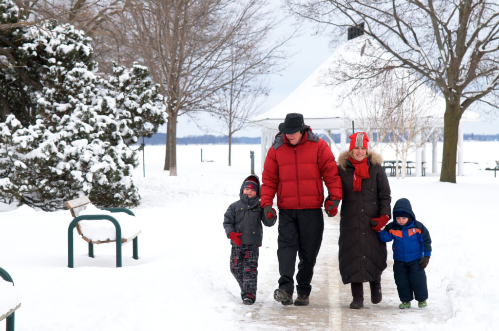 Family walking through snow in a park