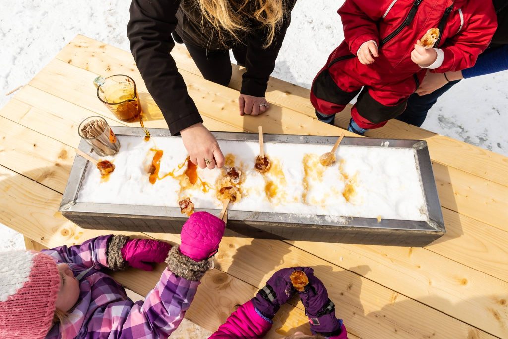 People making maple taffy on snow