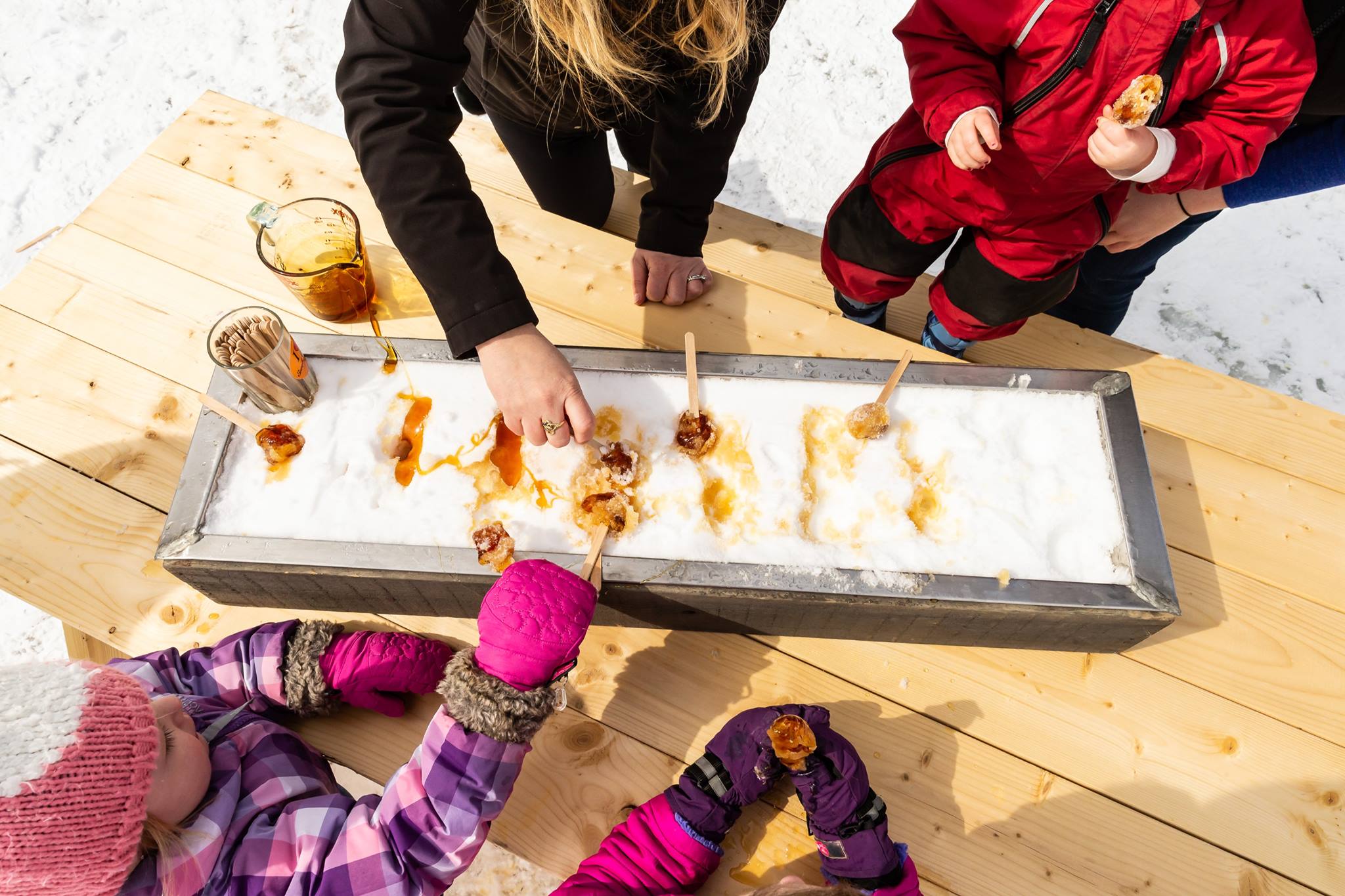 People making maple taffy on snow