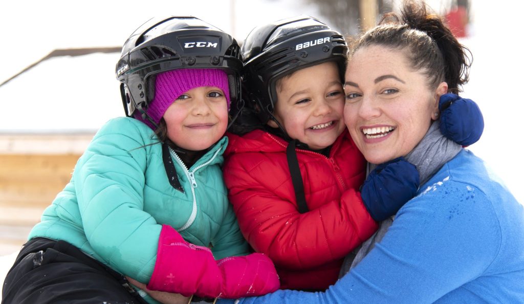 Mother with two children wearing winter helmets
