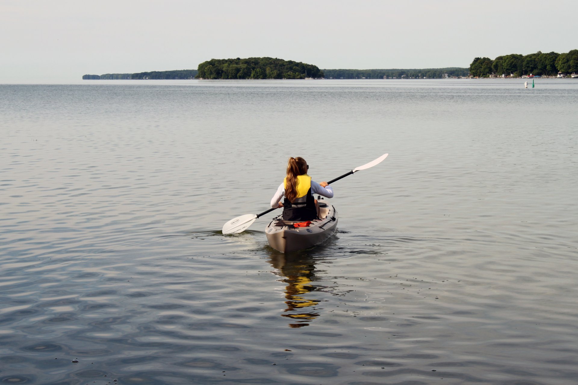 Person paddling toward an island on Lake Couchiching