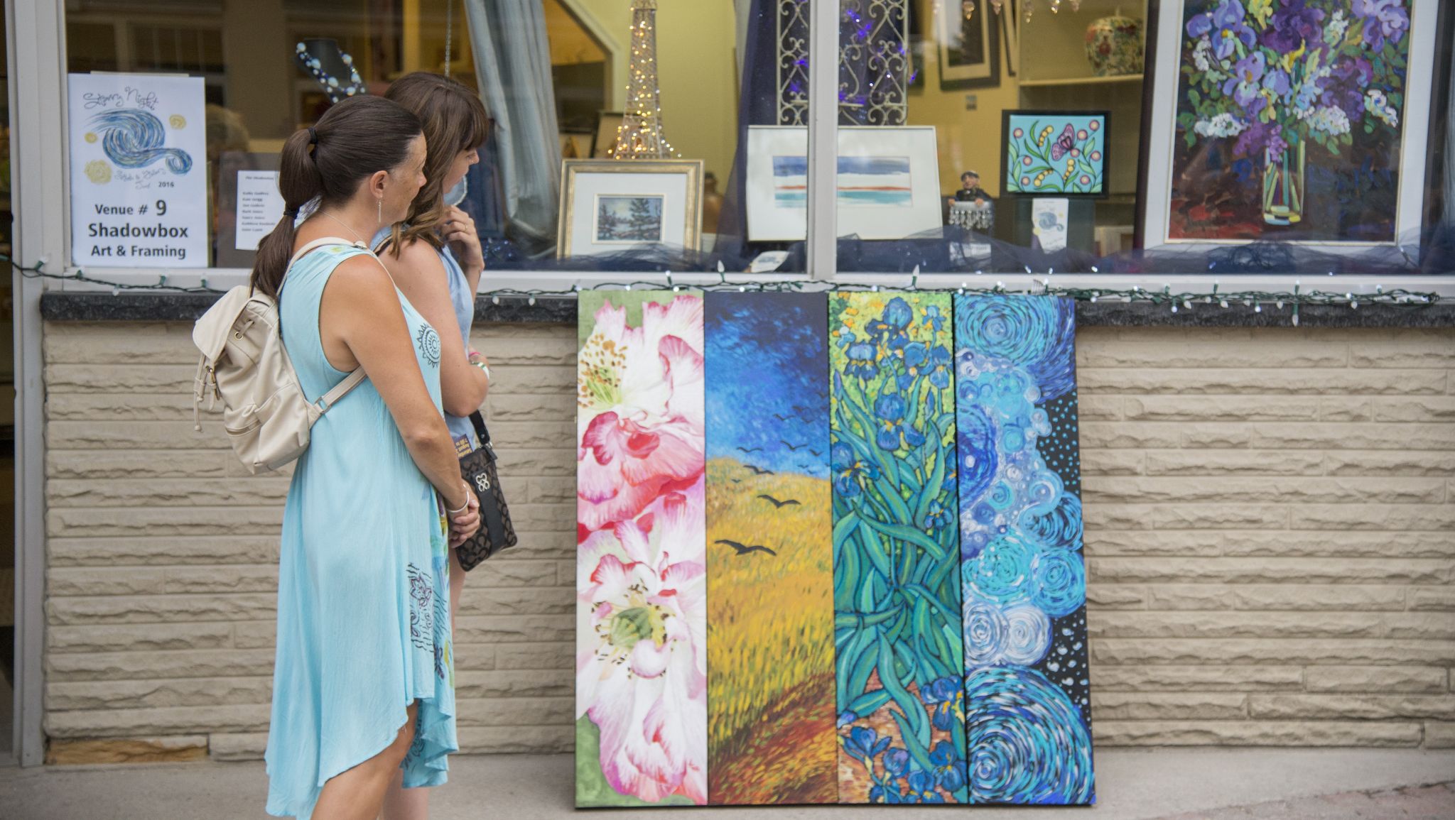Woman viewing outdoor art displayed on a wall
