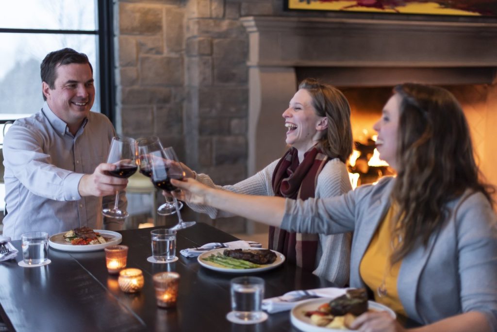 The Ktchn fine dining three people cheersing with wine glasses