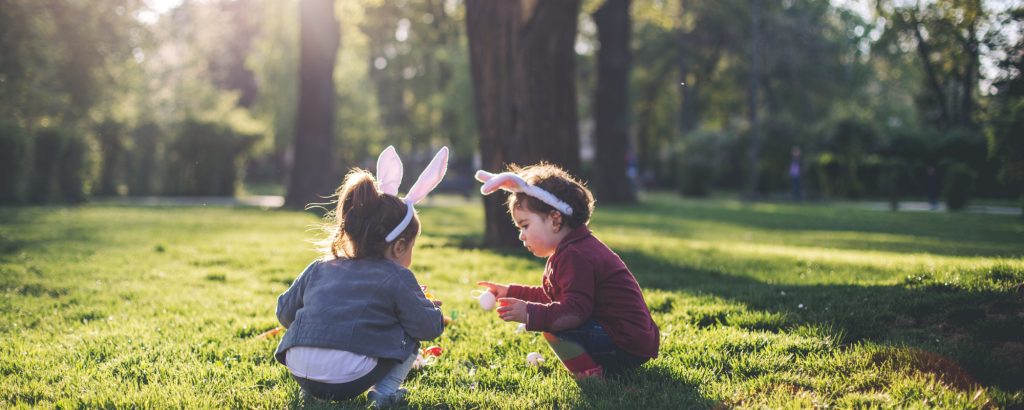 Two children playing outside in a sunny park