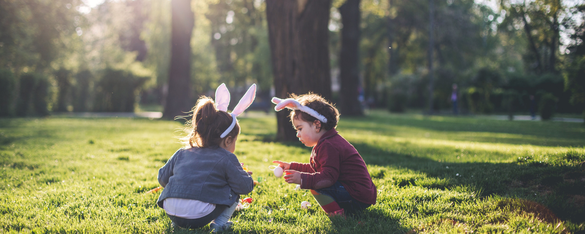 Two children playing outside in a sunny park
