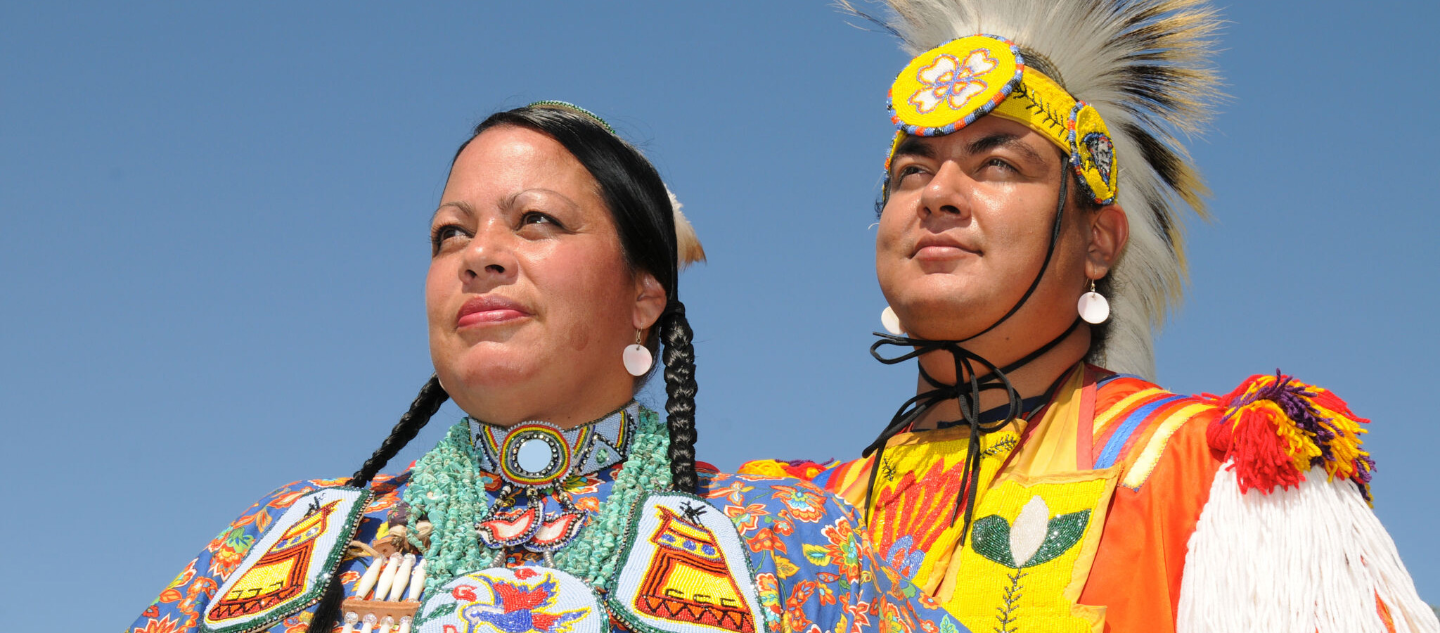 Two Indigenous women wearing traditional regalia